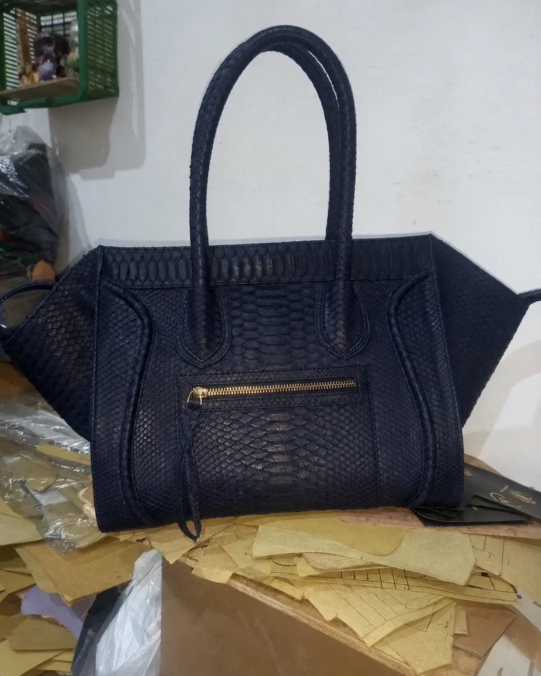 Tas tangan kulit navy bertekstur dengan pegangan berlapis dan ritsleting emas
